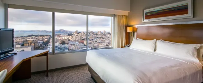 Image of our king guest room showing work desk and views of the city and the bay