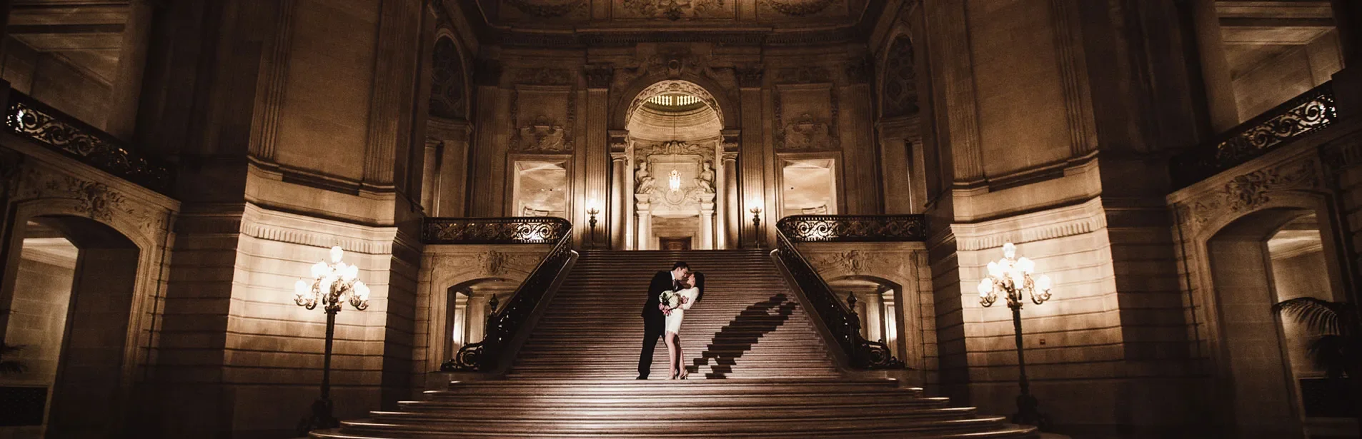 couple embracing on the grand staircase of San Francisco's City Hall